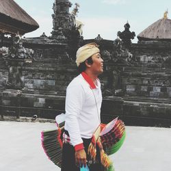 Full length of man standing outside temple against building