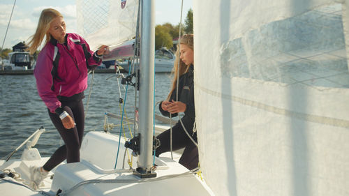 Young woman with girl standing on boat