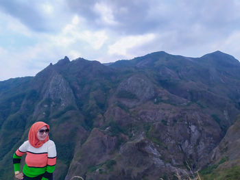 Woman with mountain range against sky