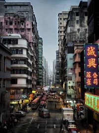 Traffic on city street by buildings against sky