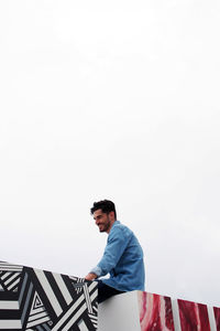 Low angle view of man standing against clear sky