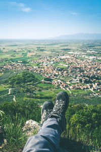 Trekking shoes and mountain panorama. male legs, feet with technical hiking boots. relax on the top