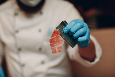 Midsection of chef holding clamp in kitchen