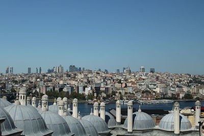 Buildings in city against clear blue sky