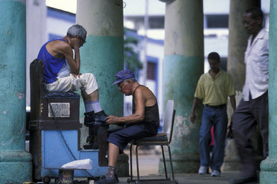 Rear view of people sitting on chair in building