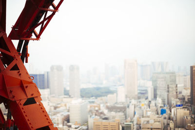 Close-up of construction machinery against cityscape