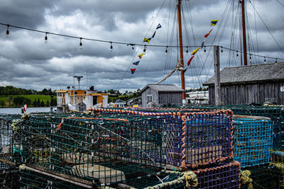 Stack of fishing net at harbor against sky