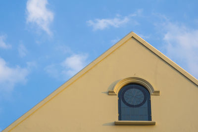 Low angle view of clock on building against sky