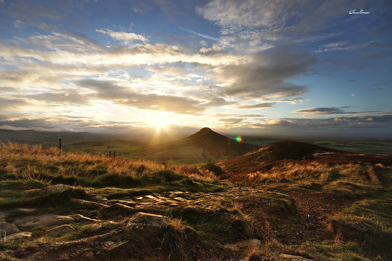 sky, environment, landscape, cloud, horizon, nature, scenics - nature, sunrise, sunlight, beauty in nature, sun, hill, land, dawn, morning, sunbeam, travel, no people, travel destinations, tranquility, wilderness, outdoors, sea, non-urban scene, plant, tourism, tranquil scene, dramatic sky, grass, lens flare, plateau