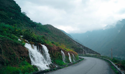 Road amidst mountains against sky