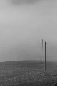 Electricity pylon on field against sky