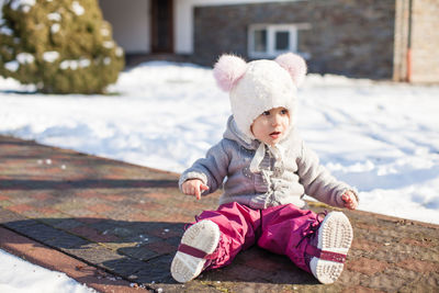 Cute baby girl sitting in park during winter