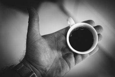 Cropped hand of man holding coffee cup