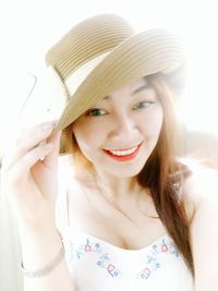 Portrait of smiling young woman wearing hat at home