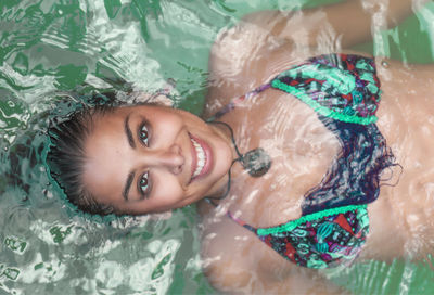 Portrait of young woman swimming in pool