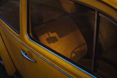 Reflection of yellow car on window