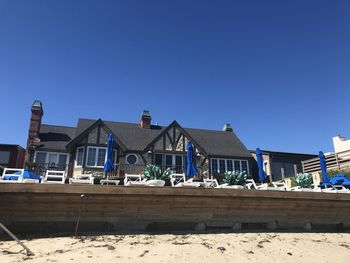 Houses on beach against clear blue sky