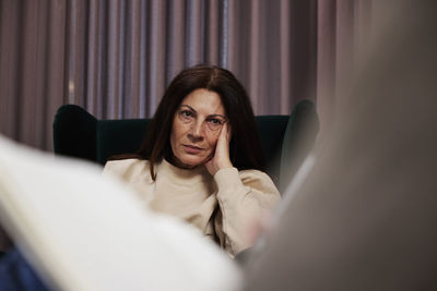 Female patient sitting in armchair at therapy session