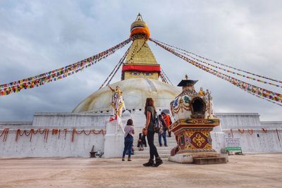 People at temple against building