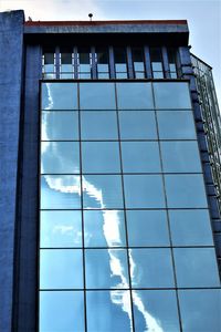 Low angle view of glass building against sky