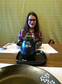 Portrait of young woman sitting on table