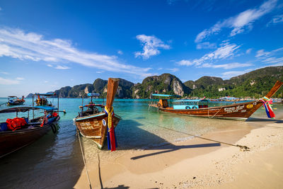 Boats moored on beach against sky