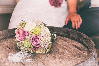 Close-up of woman holding bouquet in front of flowers