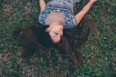 High angle view of young woman lying on grass