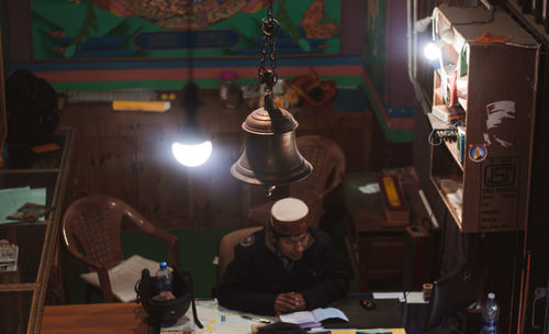 Midsection of man with illuminated light bulb