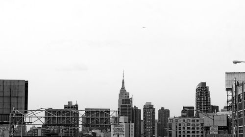 Buildings in city against clear sky