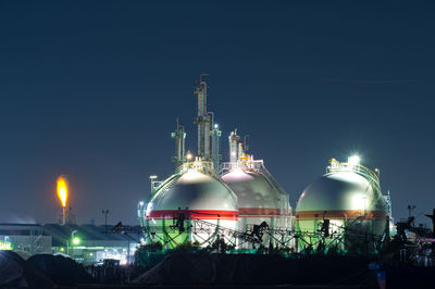 Factory night view with gas tank and flare stack