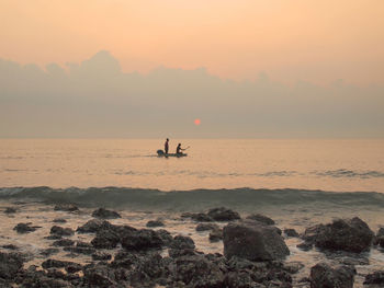 Silhouette boat in sea against sky during sunset