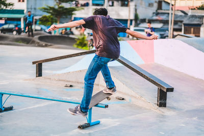 Rear view of man skateboarding on skateboard