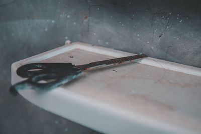 Close-up of stained scissor on shelf