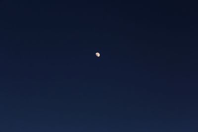 Low angle view of moon against clear blue sky