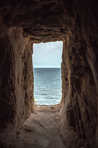 Scenic view of sea seen through cave