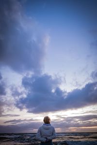 Rear view of woman looking at sea against sky