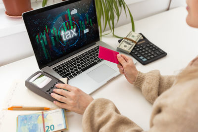 Cropped hand using laptop on table