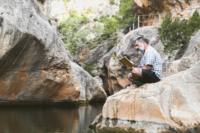 Man reads a book while enjoying the tranquility of the mountain