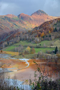 Scenic view of lake by mountain against sky