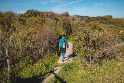 Rear view of woman walking on field