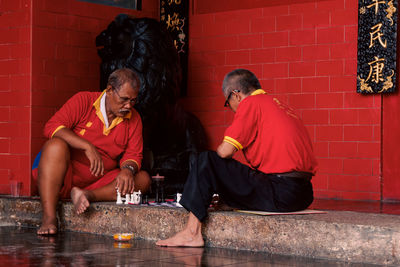 The photo shows two older men playing chess during the chinese new year 