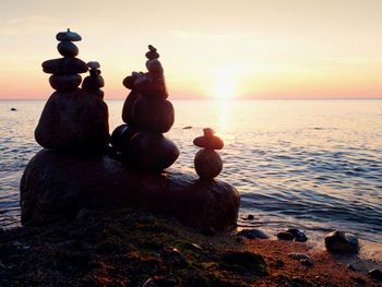 Scenic view of rocks on beach during sunset