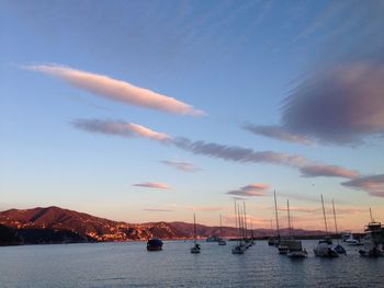 Boats in sea at sunset