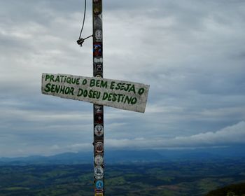 Information sign against sky