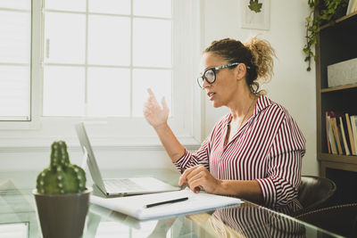 Woman sitting on table at home