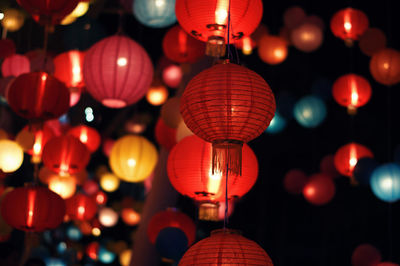 Low angle view of illuminated lanterns hanging at night