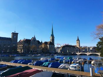 Boats in canal by buildings against sky in city