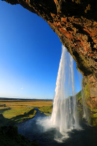 Scenic view of waterfall against sky