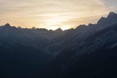 Scenic view of snowcapped mountains against sky during sunset
